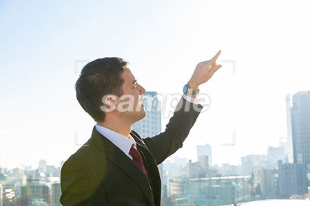 右を向いて空を指差すビジネスマンの男性の写真 Aph Prismgraph プリズムグラフ