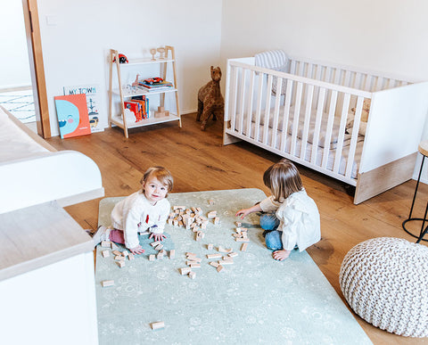 Girls playing with wooden toys on Green Playmat