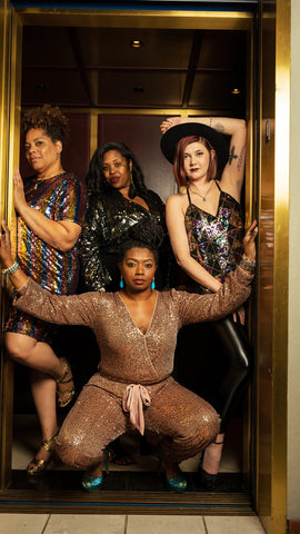 4 women modeling sequin outfits pose together