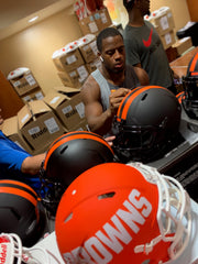 Nick Chubb autographing Cleveland Browns Eclipse Helmets