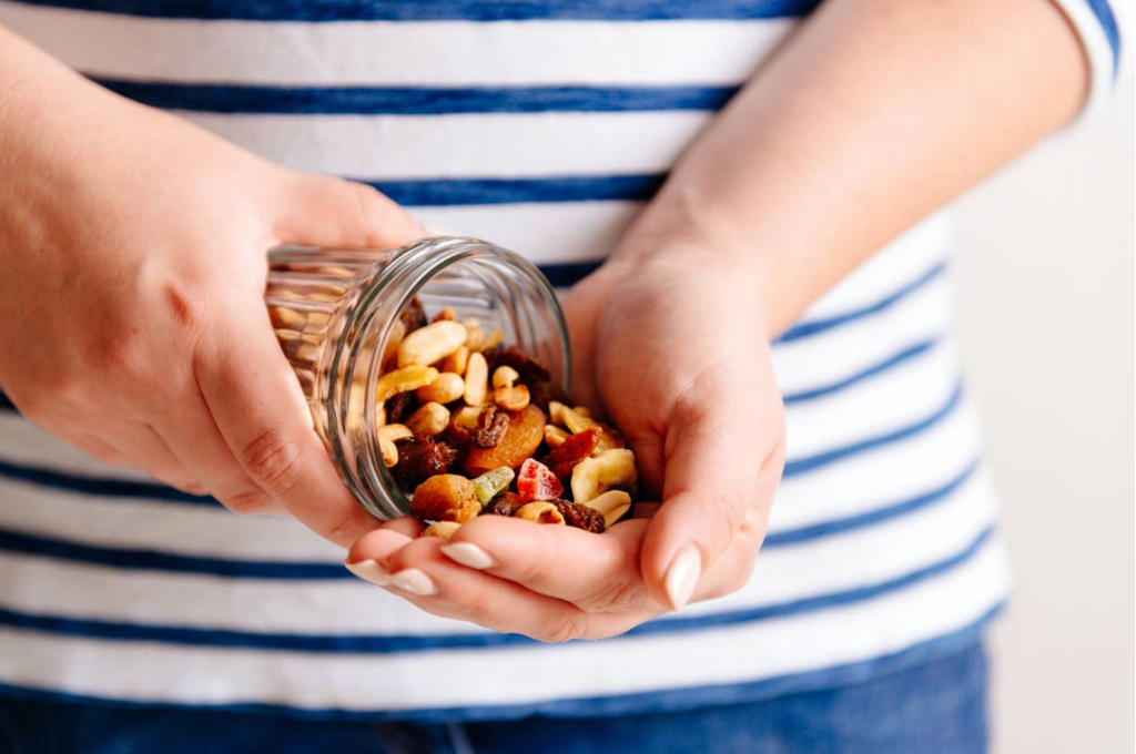 woman pouring out a jar of nuts