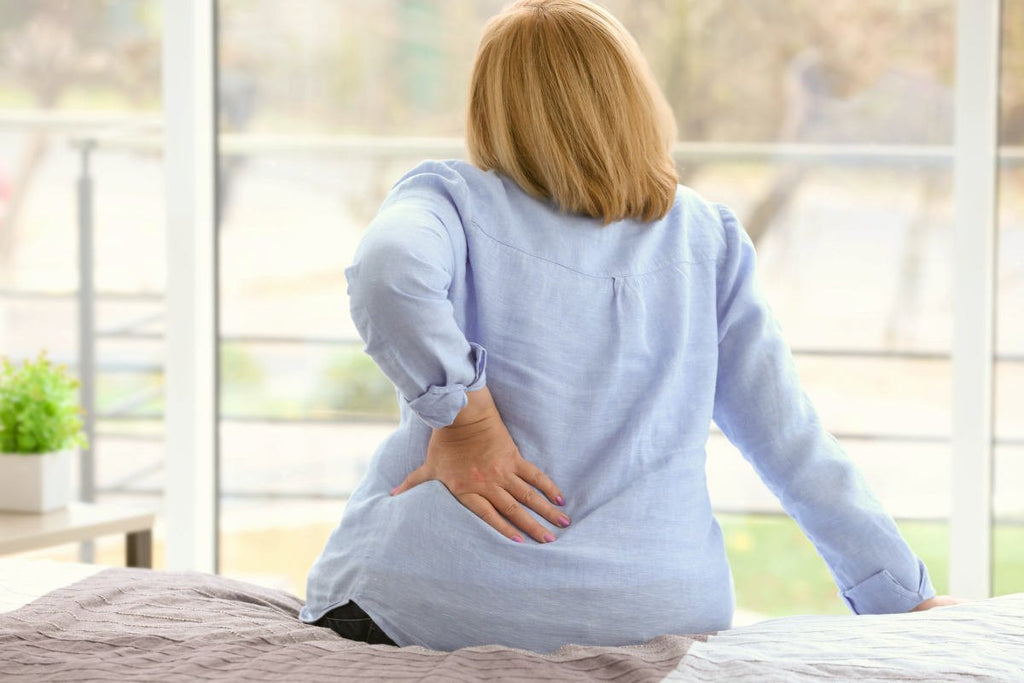 Senior woman suffering from backache at home | Calcium To Magnesium: How The Ratio Affects Your Health | do calcium and magnesium compete for absorption