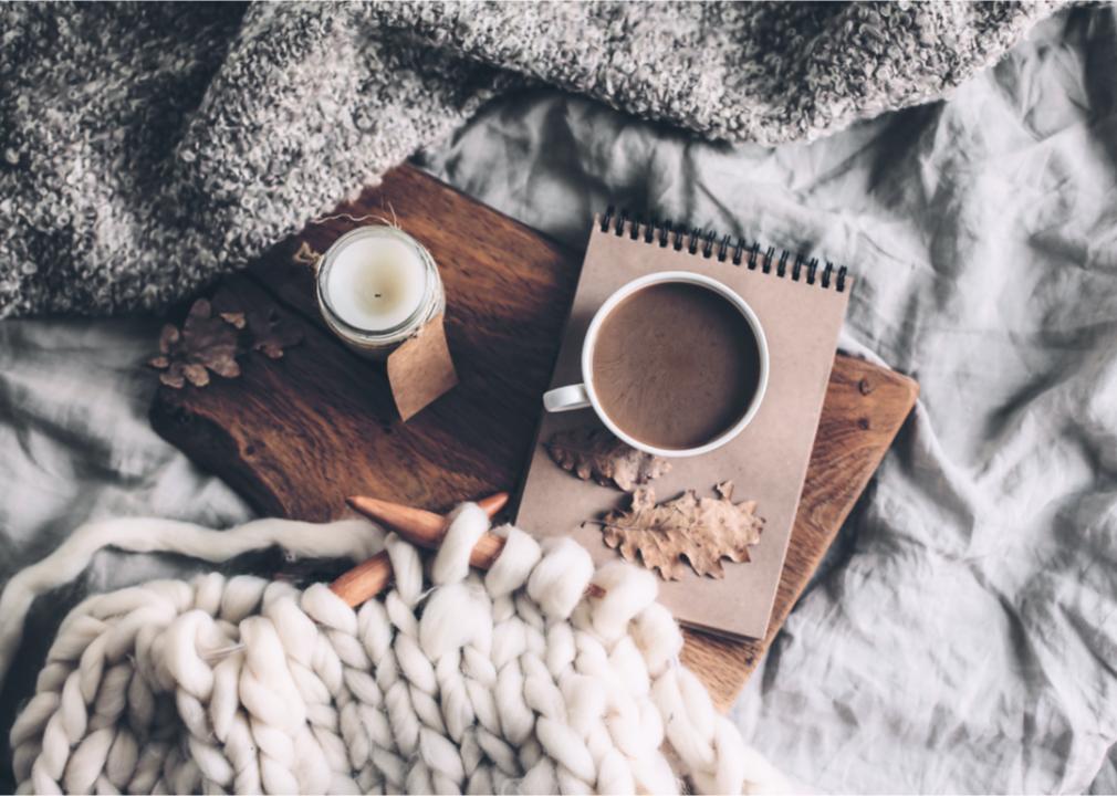 Coffee on top of cozy blanket. Cozy winter essentials. Cozy winter necessities. Cozy warm blankets.