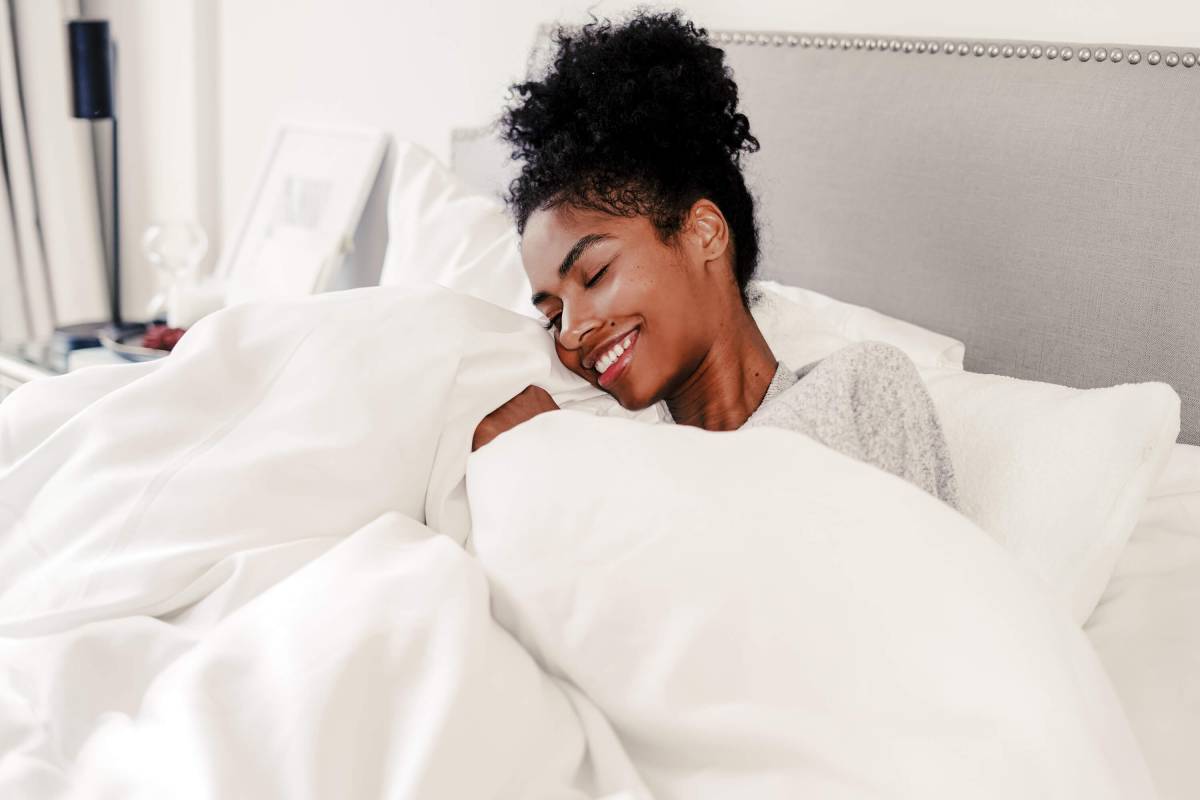 Bedding Fabric. Woman holding blanket to face. Woman holding bedding to face. Woman cuddling bedding.