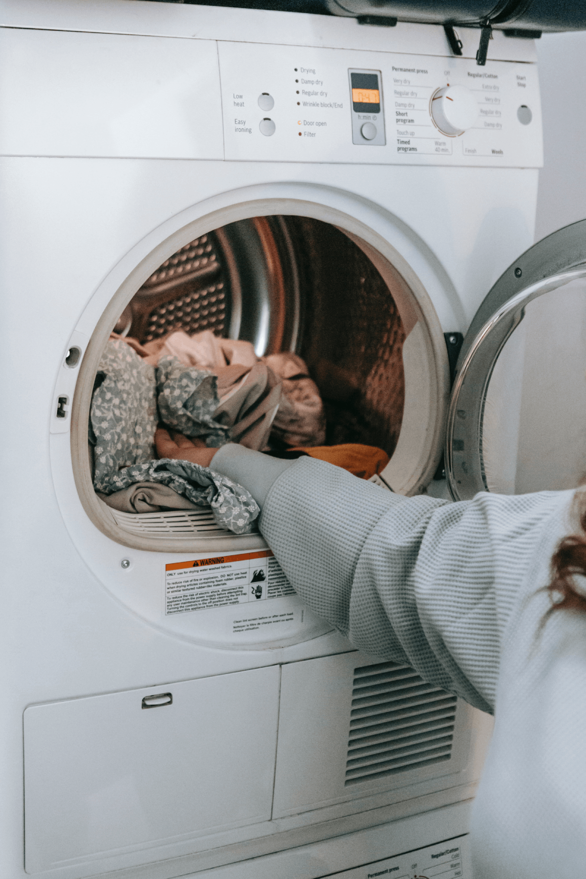 Putting laundry in the machine. Putting clothes in the washing machine. Clothes in the washer. Washer and Dryer. Washing machine. Loading the laundry.