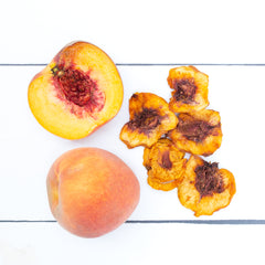 Fresh peach next to dried peaches