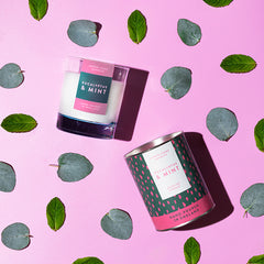 Eucalyptus & Mint Luxury scented candle from Lower Lodge Candles Colour Pop! collection pictured with its cardboard tube packaging against a pastel pink background with eucalyptus leaves
