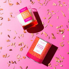 Sandalwood & Cashmere Luxury scented candle from Lower Lodge Candles Colour Pop! collection pictured with its cardboard tube packaging against a bright pink background with wood chippings