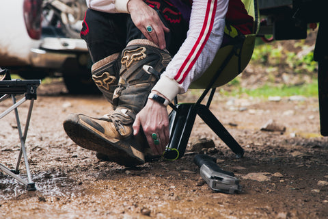 Putting on boots in the mud