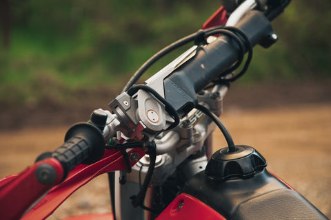 Combar strapped to the handle bar of a dirt bike