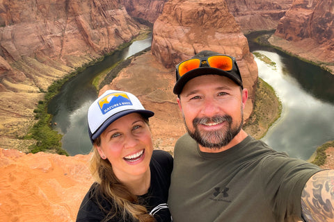 a man and woman smiling in front of a desert background