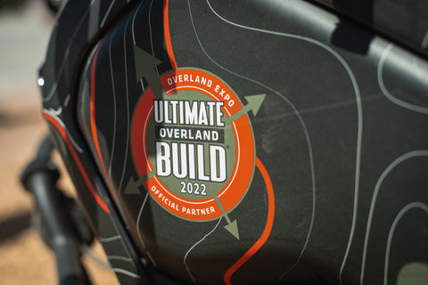 The "Ultimate Overland Build" logo on the gas tank of an ADV motorcycle