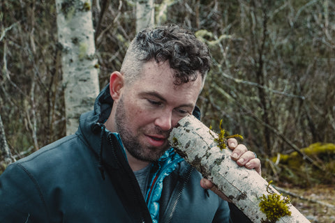 survivalist Trevin Baker checks the dampness of a freshly sawn log