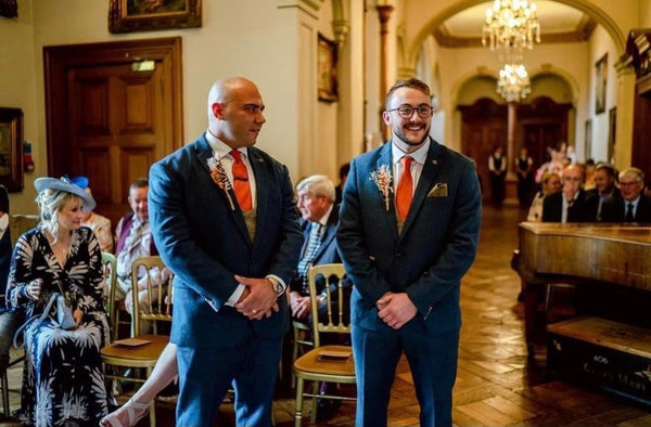 Groom and Best Man stand at front of aisle.