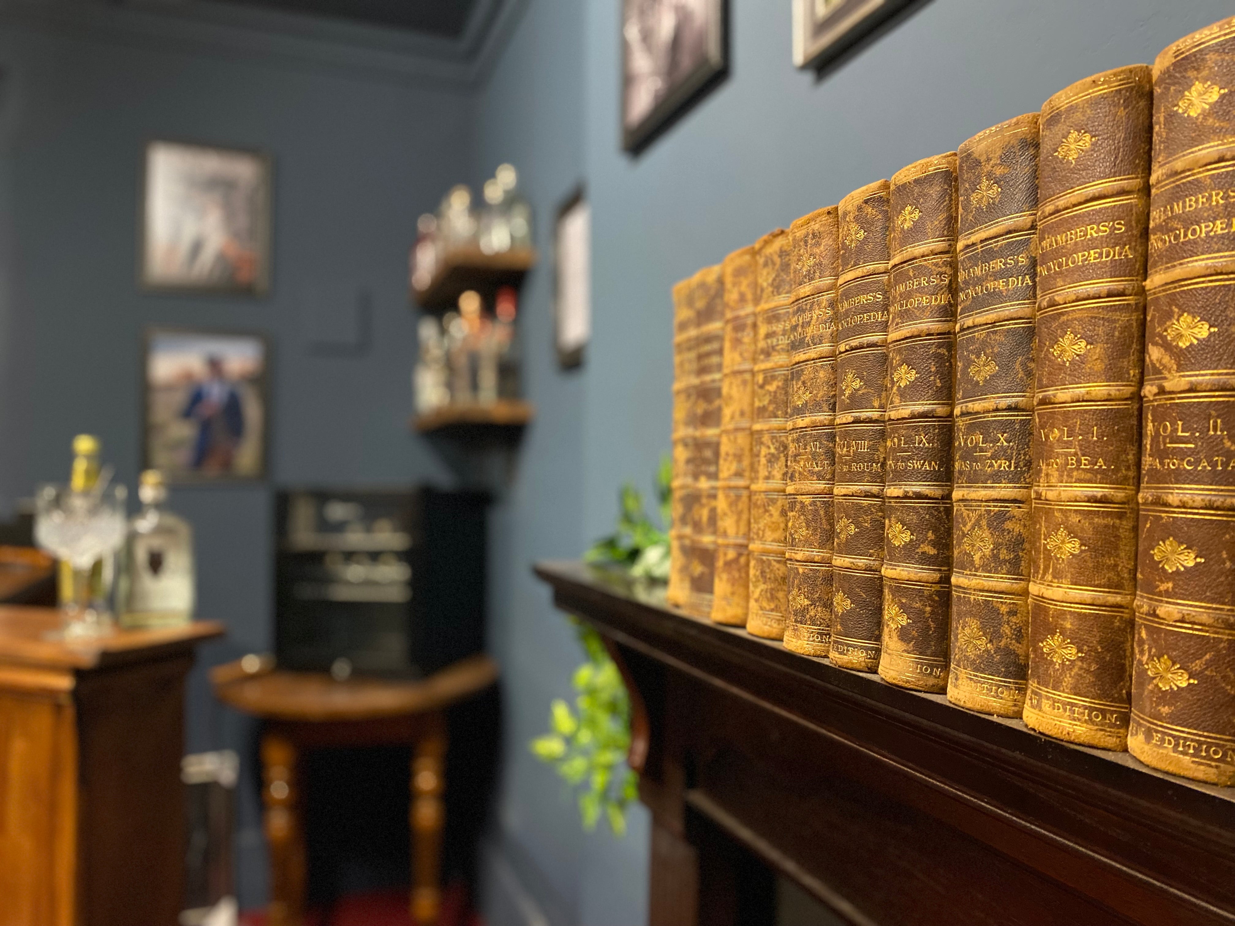 Bound books sit on a mantle. In the background, we can see the bar. 