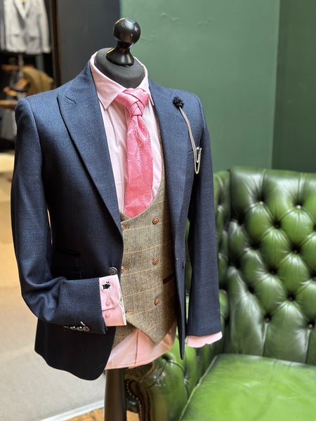 Navy suit jacket for men with brown waistcoat for men styled with pink accessories and pink men's formal shirt displayed on mannequin.