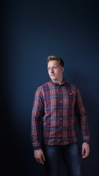 Plum lumberjack shirt on model displaying casual outfit for men.