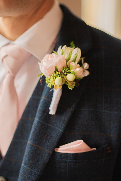 Close up on Cody suit with pale pink accessory details for wedding