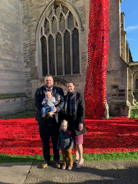 Co-founders Tony and Jessica with their two sons alongside a church's poppy display.