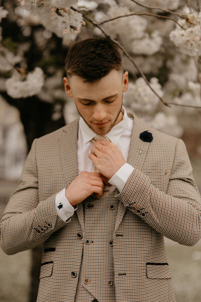 Model wears a cream suit for men with champagne accessories