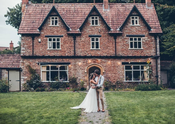 Bride and groom embrace outside of venue.