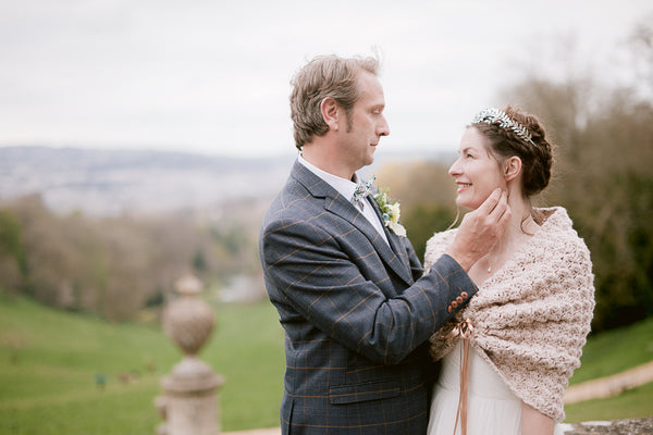 Groom and bride in venue gardens with view of Bath city.