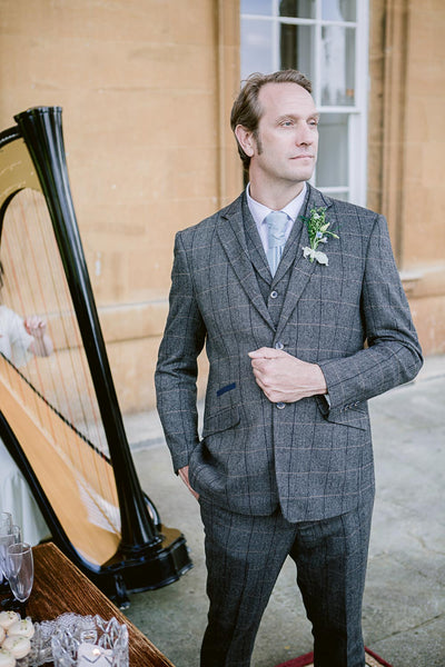 Groom wearing Albert Grey suit outside Prior Park venue with harpist playing.