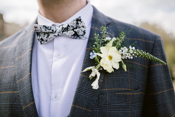 Groom wearing navy suit for men with floral boutonniere