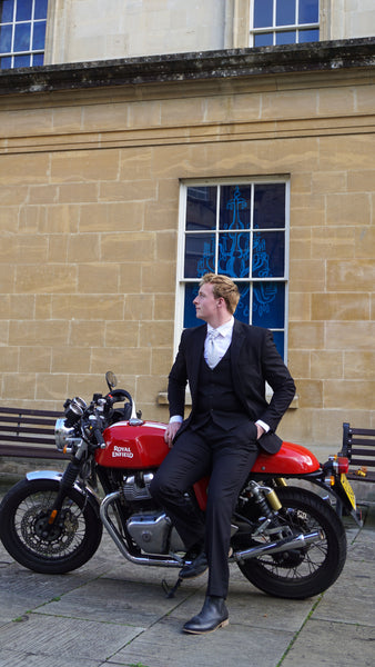 Black suit for men worn by model on a motorbike outside Assembly Rooms