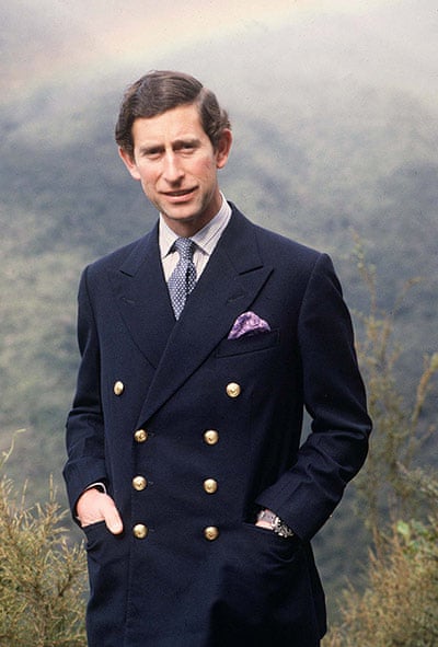 A young King Charles is wearing a double breasted navy coat with a white shirt and blue accessories.