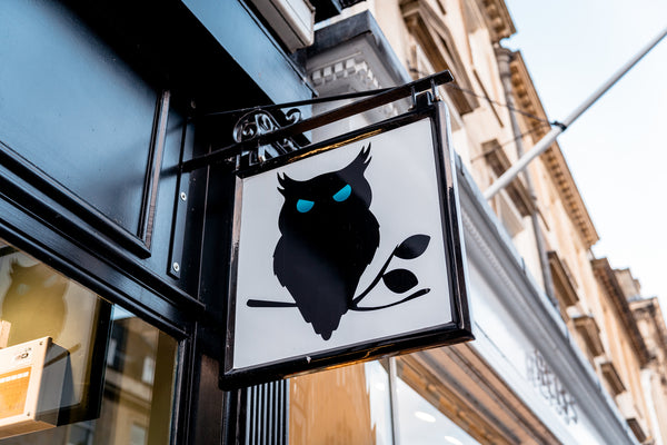 The SUAVE OWL logo on the sign outside the Milsom Street, Bath store. 