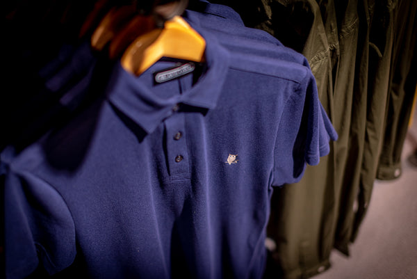 A SUAVE OWL polo shirt is displayed on a rack with a SUAVE OWL logo visible. 