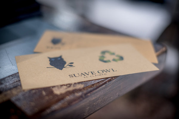 SUAVE OWL Reclaimed promotional materials sit on a wooden counter. 