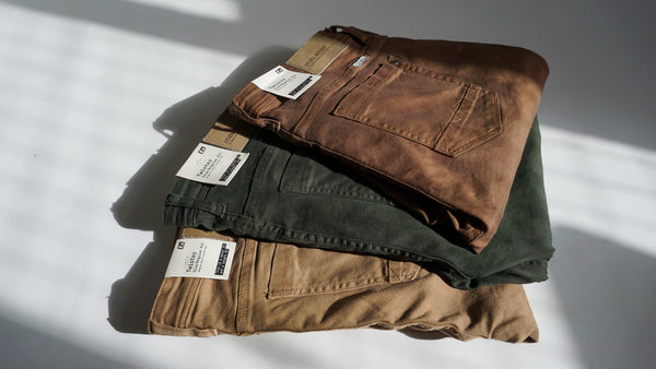 Brown jeans, olive jeans, and bronze jeans photographed in pile.