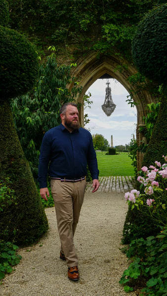 Co-founder Tony in garden wearing smart casual men's outfit.