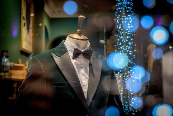 Rosa Jacket on mannequin with white shirt and black tie. Christmas lights visible in front.