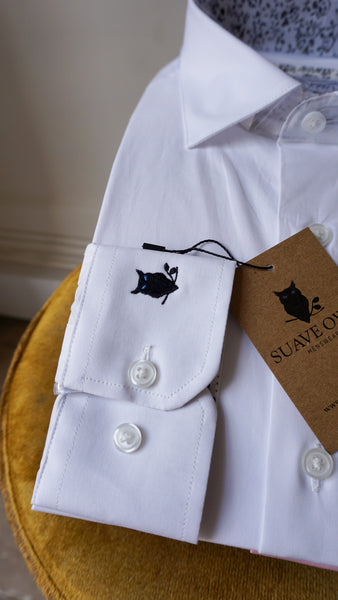 White shirt folded on display with SUAVE OWL logo visible on sleeve and tag.