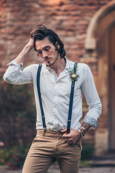 Groom wears smart-casual wedding attire, a formal shirt, braces, and chinos.