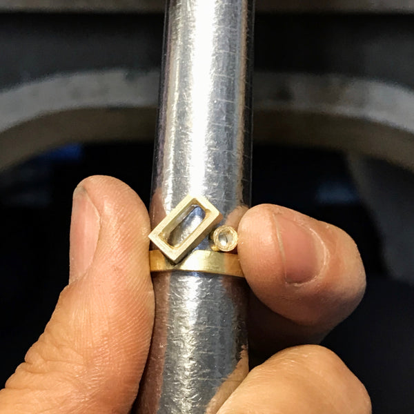 photo of a work in process gold ring without the gemstones set