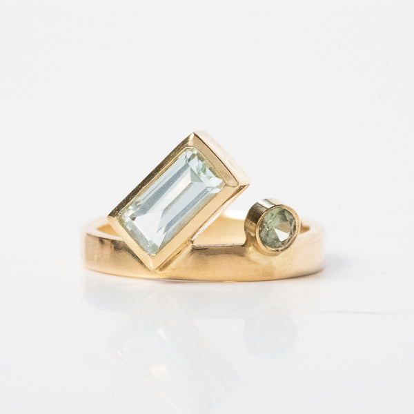 photo of a finished gold ring with bezel set aquamarine and sapphire gemstones