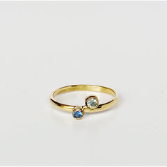 gold ring with small, bezel set light blue and dark blue sapphires