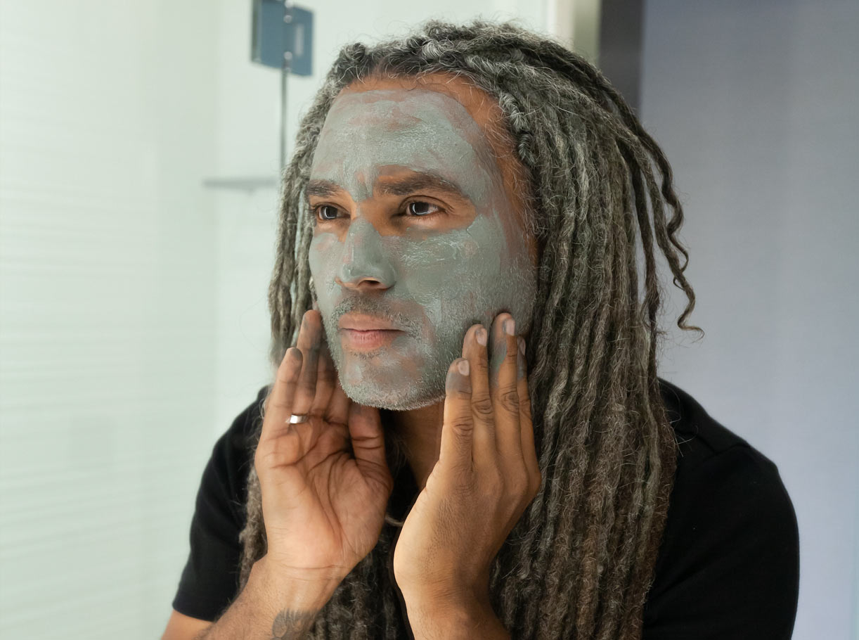 Man with Caldera Lab product The Deep applied to his face looking in mirror