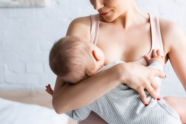 Mother feeding breast with nursing pillow