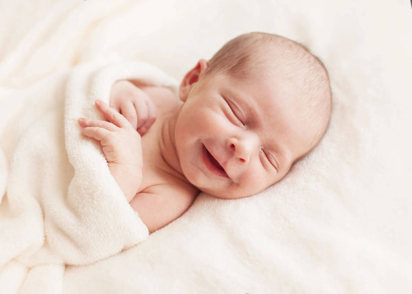 Newborn baby girl asleep on a blanket