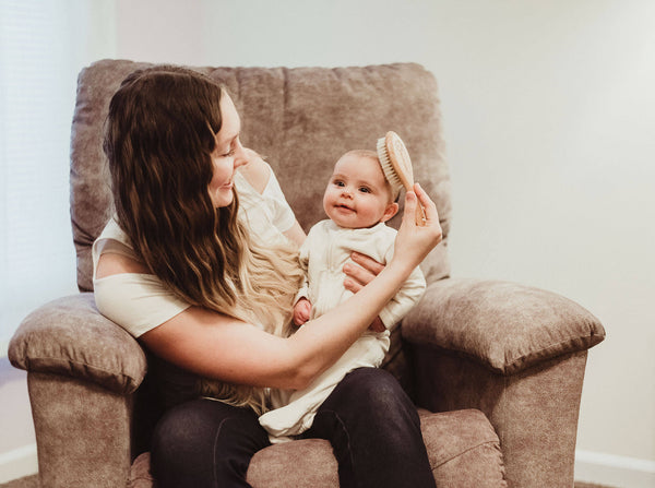 Mother brushing baby's hair 