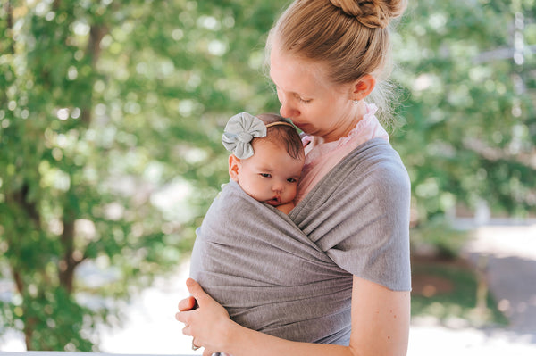 mother wearing her baby using a gray KeaBabies Baby Wrap Carrier
