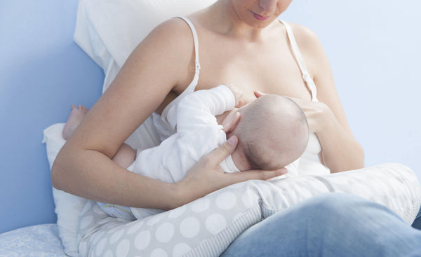 Mother breastfeeding with nursing pillow 