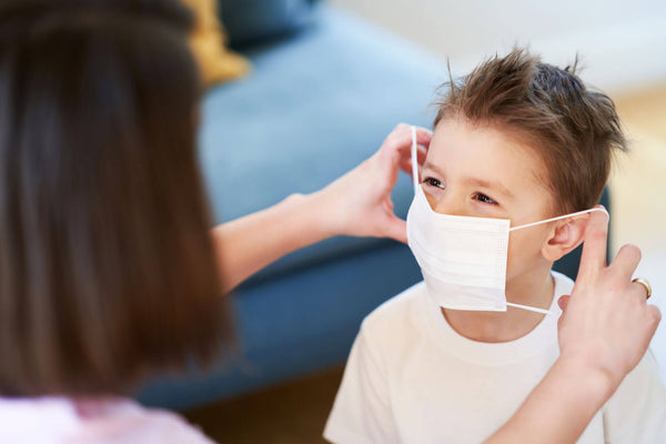 Mother and child putting on protective masks during coronavirus pandemic