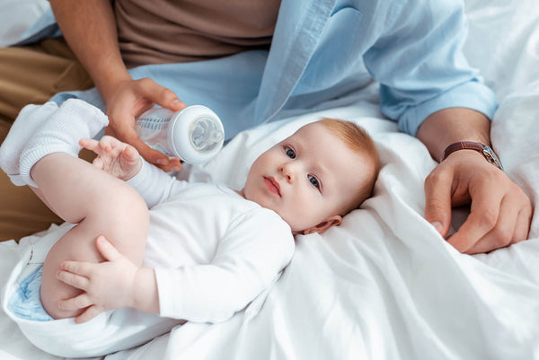 Cropped View Man Holding Baby Bottle Adorable Son Lying Bed