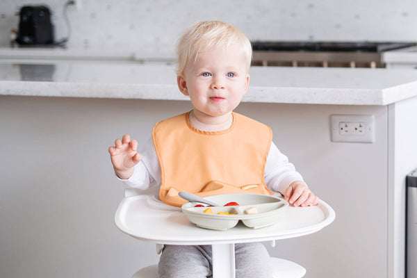 baby eating on high chair